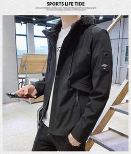 Detail of men's black hooded sports jacket showing decorative arm patch and zipper pocket