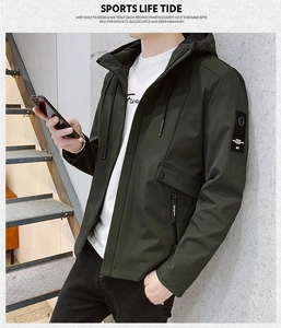 Detail of olive green hooded jacket showing side zipper pocket and arm patch insignia