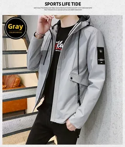 Detail of light grey windbreaker jacket featuring black drawstring and sleeve patch