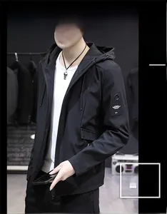 Detailed close-up of men's black hooded jacket with stylish industrial sleeve patch