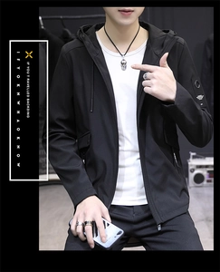 Detail of a men's black hooded jacket featuring a zip closure and badge on the sleeve