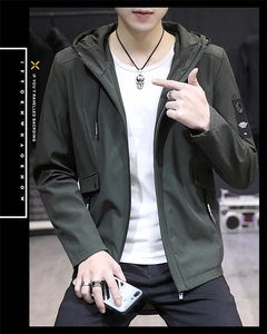 Detail of olive green hooded jacket showing sleeve patch and zipper with adjustable drawstring
