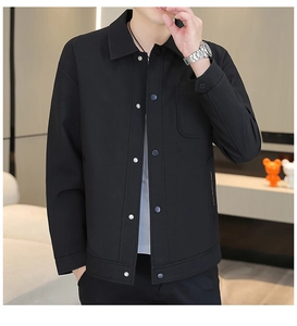 Detail of black shirt jacket featuring fine vertical ribbed texture and metallic snap buttons