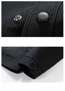 Detail view of the black textured jacket featuring metal snap buttons and windproof cuffs