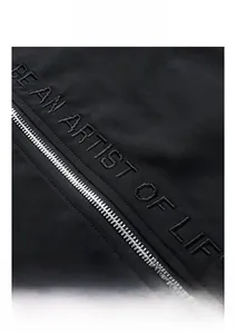 Detail of 3D embroidered lettering and premium metal zipper on black casual jacket