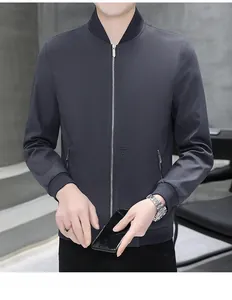Detail of dark grey stand-collar jacket with vertical embroidered lettering and zipped pockets