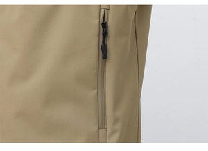 Close-up of functional vertical zipper pocket on khaki outdoor vest with smooth stitching