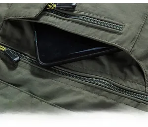 Macro shot of large chest zipper pocket on outdoor vest holding a smartphone for storage