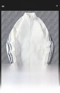 Détail de veste blanche à col montant avec rayures bleu marine sur les manches et poignets élastiques