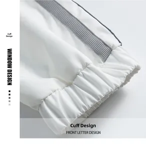 Détail des poignets élastiques blancs avec rayures grises sur une veste pour hommes