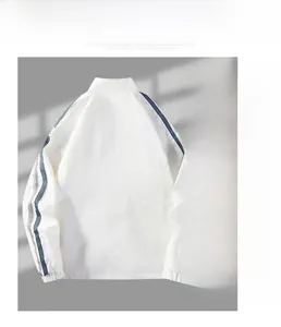 Détail de la veste à col montant blanc avec bandes latérales bleu marine et tissu de sport lisse