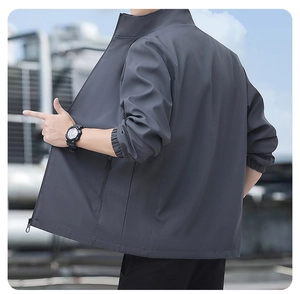 Detail view of charcoal grey windproof jacket featuring elastic cuffs and side zip pocket