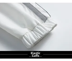 Détail des poignets élastiques de la veste blanche avec ruban tissé rayé gris