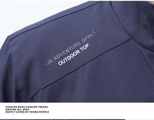 Detail of shoulder stitching on navy outdoor jacket with adventure spirit typography