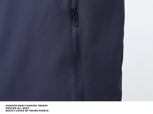 Close-up of a navy blue jacket showing a vertical zipper pocket with a pull ring