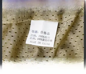 Detailed macro view of khaki jacket mesh lining and washing care label with fabric info