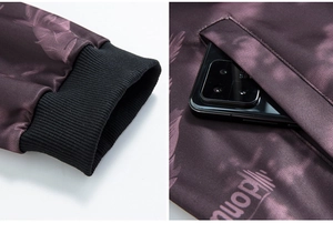 Detail of ribbed cuffs and side pocket on a purple patterned camo jacket with phone