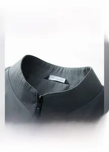 Detail view of the stand-up collar and premium zipper on this gray men's jacket