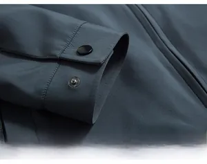 Detailed macro view of the sleeve cuff with matte metal snap button on a dark blue jacket