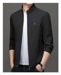 Detailed view of black stand collar jacket with fine vertical stripe texture and metal logo