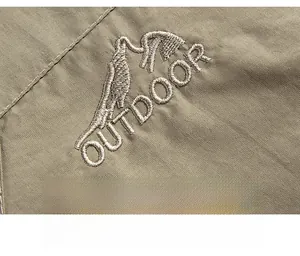 Detailed view of khaki outdoor jacket featuring premium mountain peak embroidery