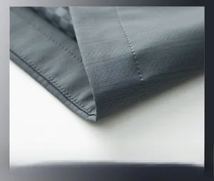 Macro shot of dark grey jacket hem featuring premium twill weave and double-stitched seams