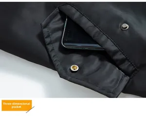 Détail d'une poche 3D avec bouton-pression métallique sur une veste de vol noire en nylon