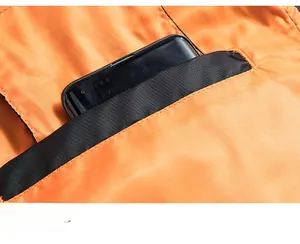 Détail de la doublure orange vif d'une veste avec grande poche intérieure pour téléphone