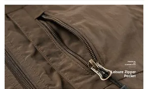 Detail of metal zipper pocket with woven puller on brown winter thermal outdoor vest