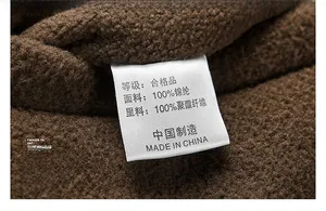 Detailed close-up of garment care label on brown thermal fleece winter vest fabric