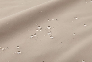Macro detail of waterproof fabric showing water droplets on outdoor jacket surface