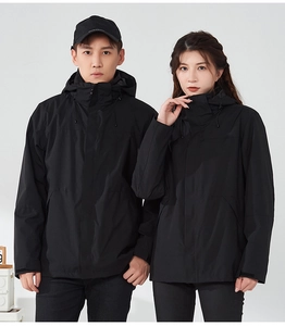 Detail view of the waterproof adjustable hood and windproof cuffs on the black outdoor jacket