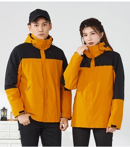 Detail of waterproof outdoor jacket featuring yellow and black patchwork with adjustable cuffs