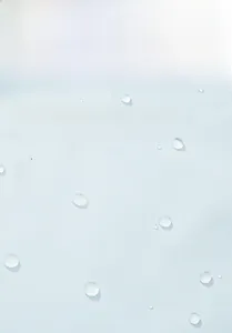 Macro view of water droplets rolling on a light blue waterproof jacket shell fabric
