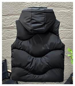 Détail de la veste sans manche à capuche noire avec matelassage ondulé et coupe-vent