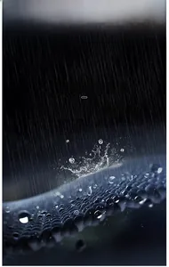 Detail of waterproof breathable fabric showing water droplets on mesh texture jacket