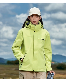 Outdoor model wearing lime green windproof hooded jacket with black zipper details