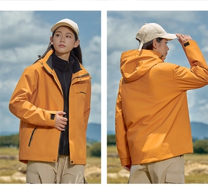 Detail of orange windproof hiking jacket with adjustable hood and zip pockets for women