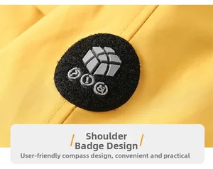 Detail of yellow outdoor jacket featuring a functional shoulder badge with compass