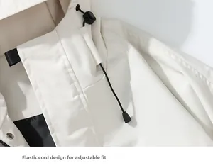 Detail of adjustable drawstring hood with toggle and metal buttons on beige outdoor jacket