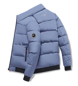 Close-up of quilted grey-blue jacket with round arm patch and black ribbed cuffs