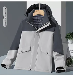 Detailed macro view of a men's hooded outdoor jacket with gray patchwork and velcro cuffs