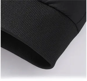 Detail view of the ribbed knit hem and smooth fabric of the black men's winter jacket