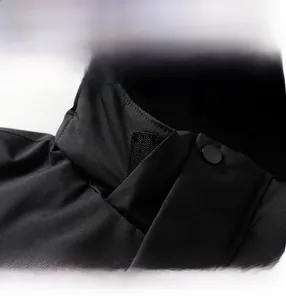 Detail view of the detachable hood with velcro and metal snap buttons on black outdoor jacket
