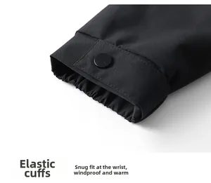 Détail des poignets élastiques avec bouton pression mat sur une veste d'extérieur noire