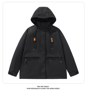 Detail of black outdoor jacket with orange drawstring toggles and hooded collar design