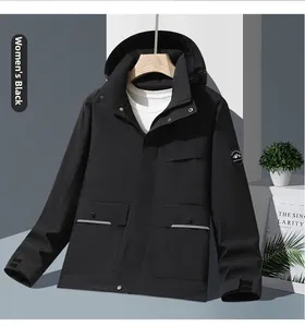 Detail of black women's outdoor jacket featuring large flap pockets and mountain badge