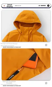 Detail of orange windbreaker jacket featuring hooded design and deep zip security pocket