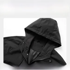 Detail of black hooded jacket with windproof fabric and metal snap button closure