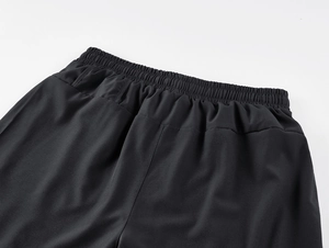 Close-up of men's athletic pants showing elastic waistband and breathable dry-fit fabric